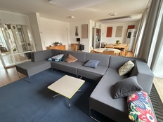 Bild zeigt das Haus 3 von innen. Zu sehen ist das Wohnzimmer mit einem gemülichen großen Sofa und einem Tisch davor