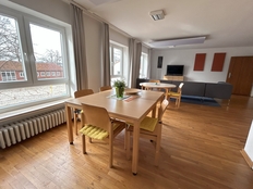 Bild zeigt das Haus 3 von innen. Zu sehen ist der Essbereich mit zwei Tischen und insgesamt 8 Stühlen