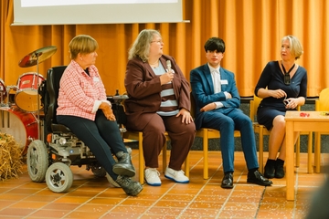 Auf dem Foto sehen Sie diskutierende Menschen zum Thema Inklusion. Sie sitzen in einem Halbrund. Ein Foto zeigt einen großen, weißen LKW - das sogenannte Hörmobil. Auf drei anderen Bildern sehen sie kulinarische Kleinigkeiten wie Warps, Salat, Gemüs